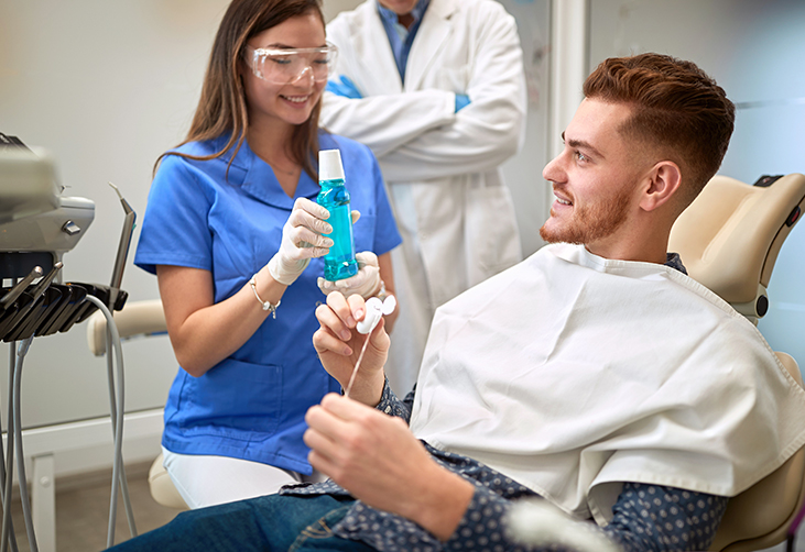 Dentist discussing proper dental care with a patient. 