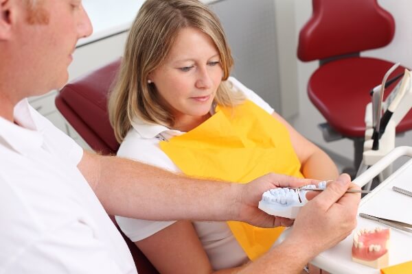 A dentist explains different dental implant options to a patient. 