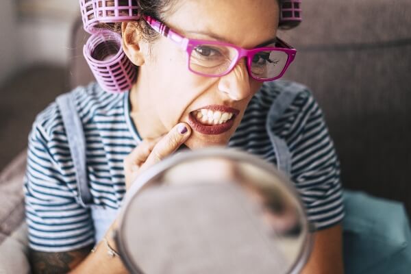 A woman inspects her teeth for any signs of tooth decay.