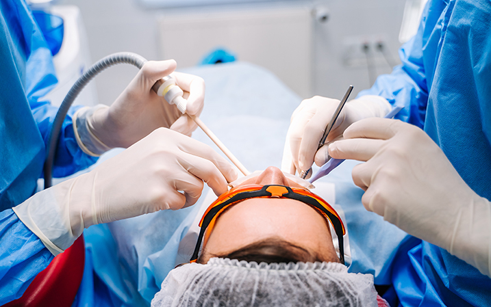 Dentists extracting a patient's tooth