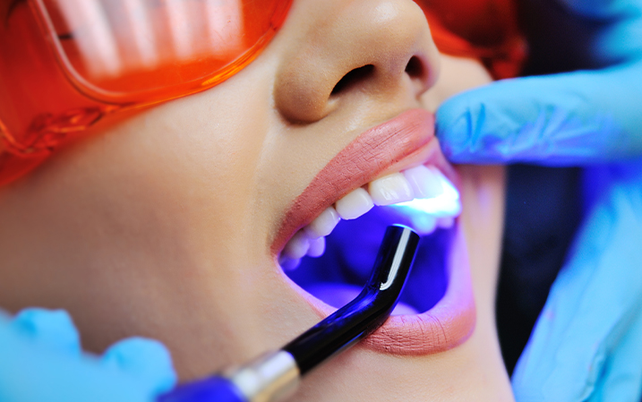 Dentist checking a patient's teeth with UV light