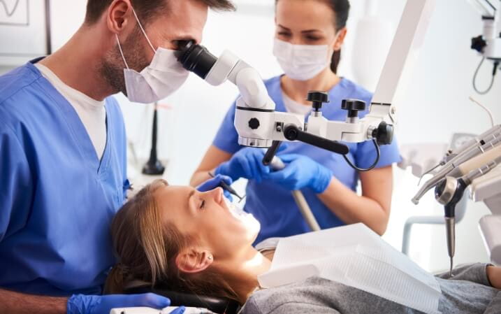 Dentist and his assistant treating a patient's teeth